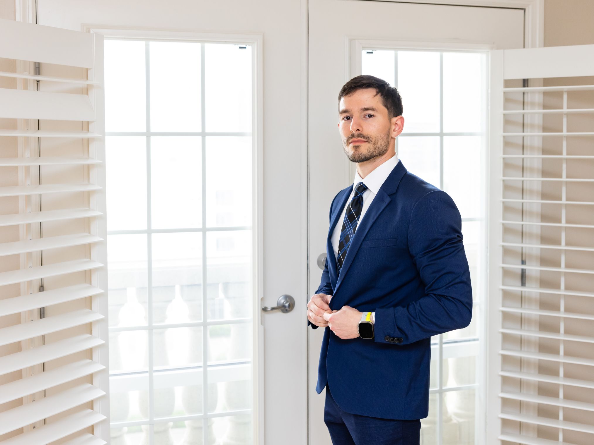 Groom posing next to doorway