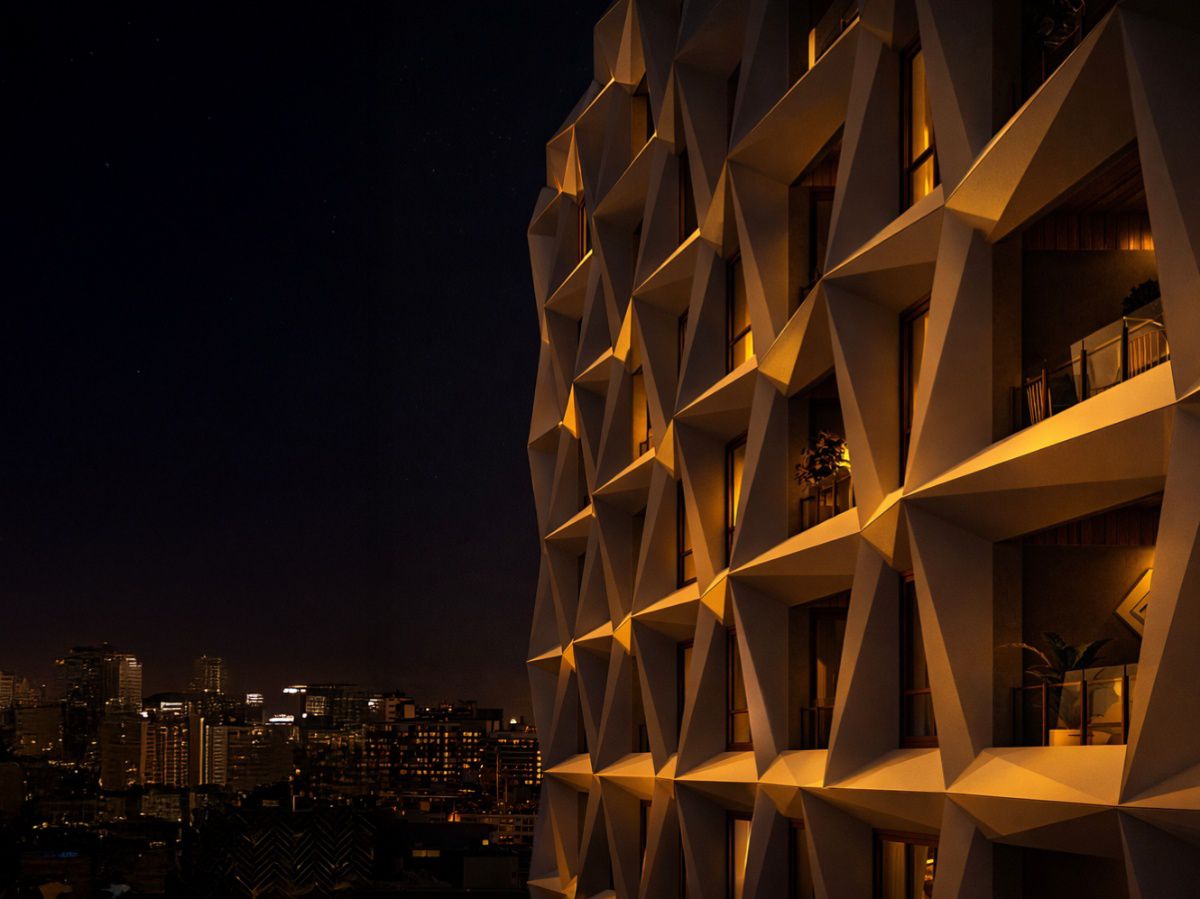 Geometric hotel facade illuminated against Brisbane's night skyline