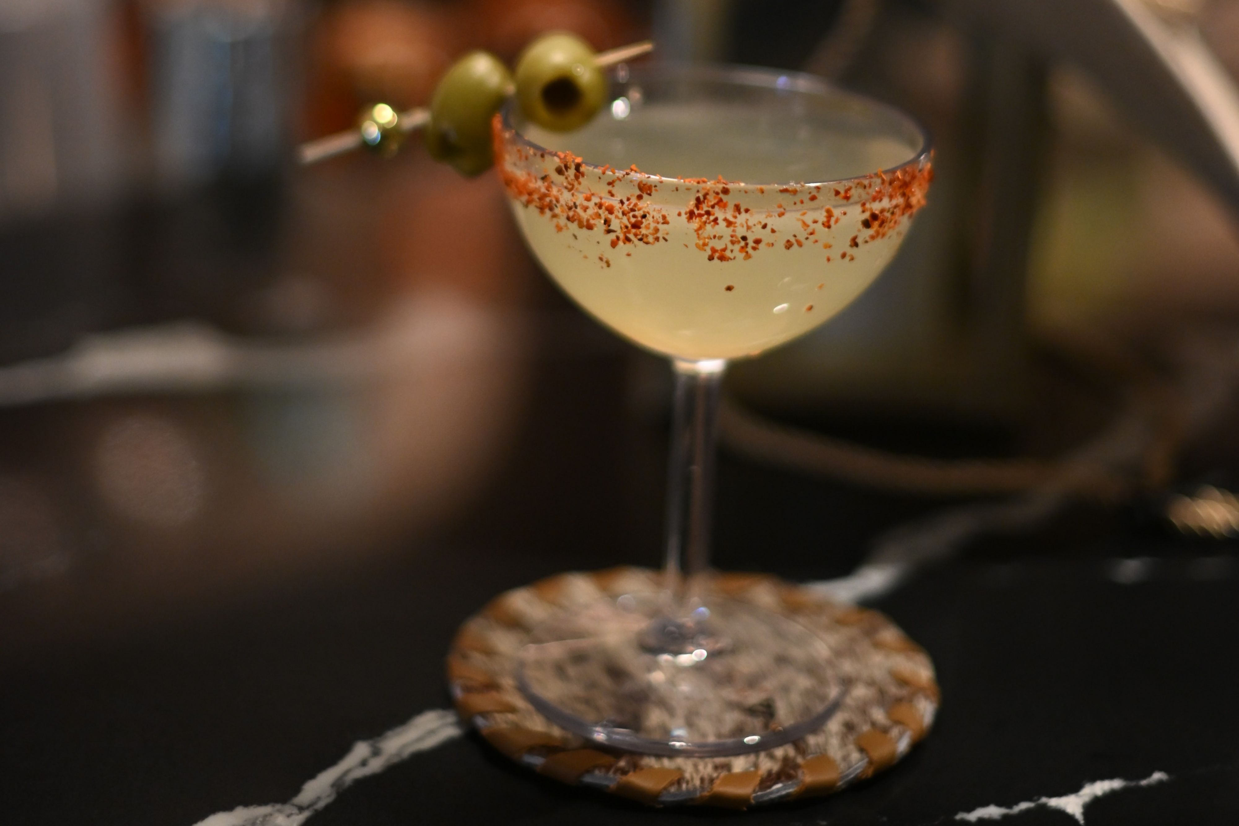 cocktail with olives and chamoy rimmed glass