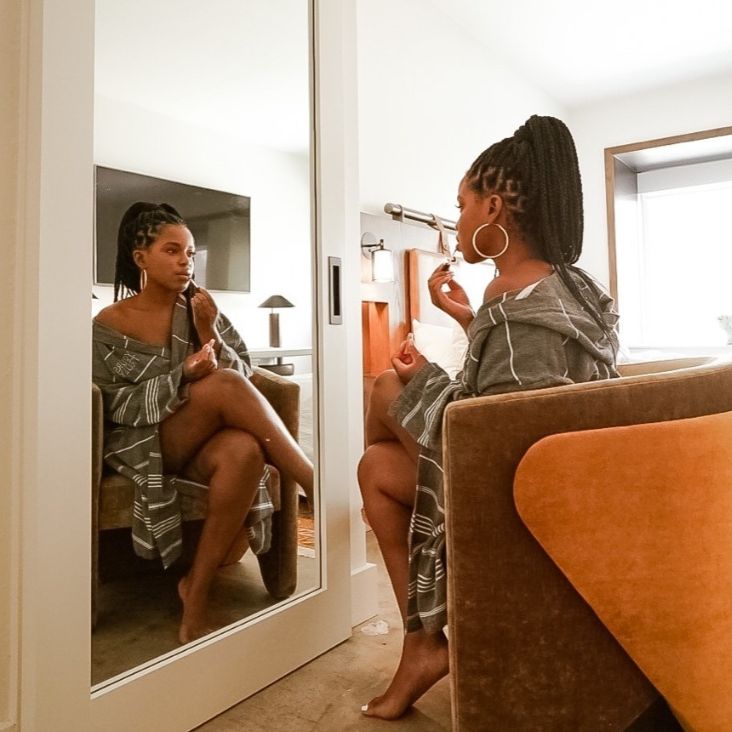Woman putting on makeup in a mirror