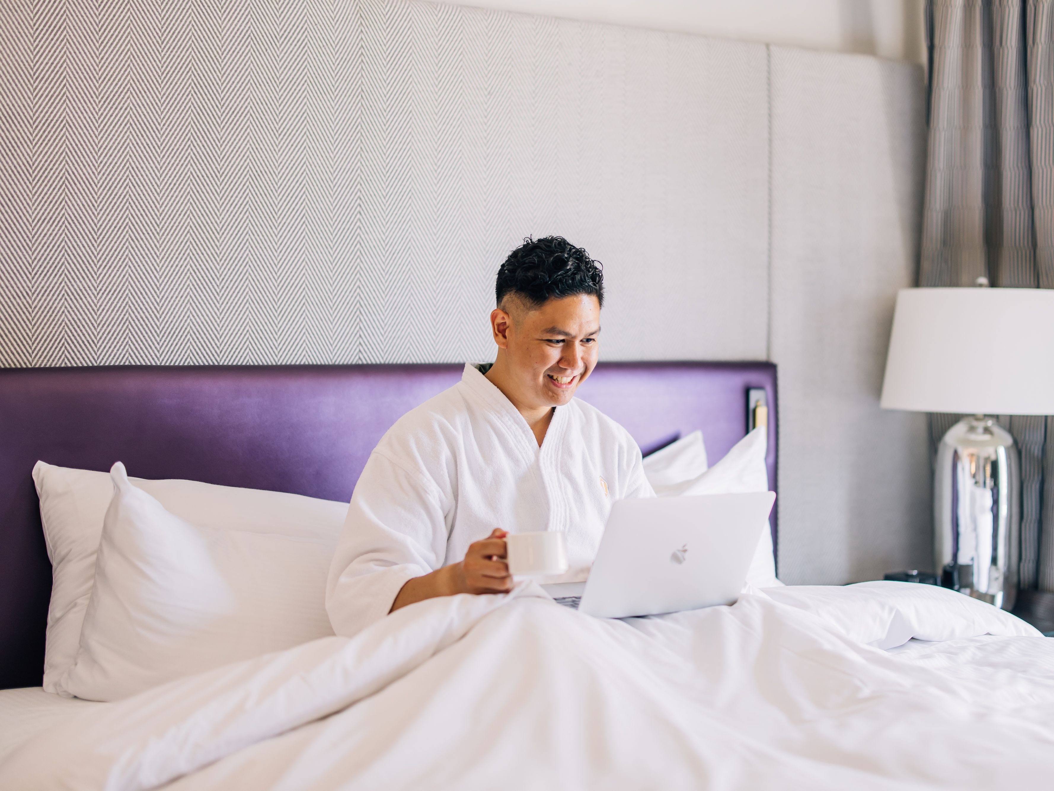 Guest on their laptop, sitting in the Presidential Suite at InterContinental Toronto Centre.