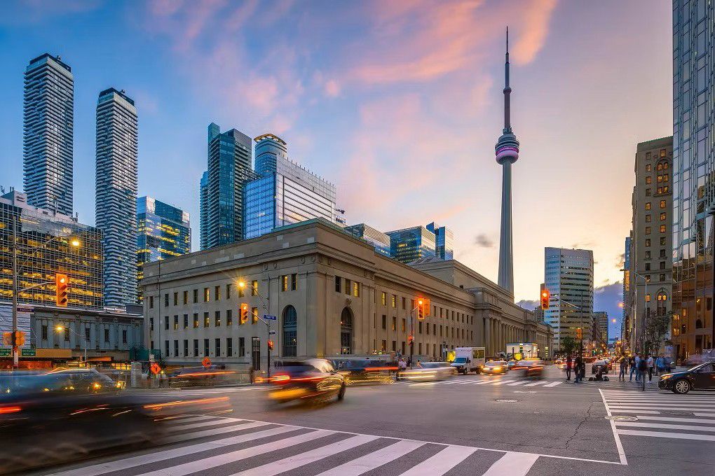 City street at sunset with skyline and tall tower
