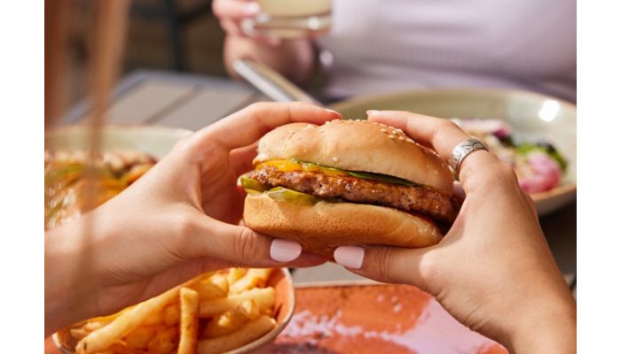 Burger with fries served at a restaurant table.
