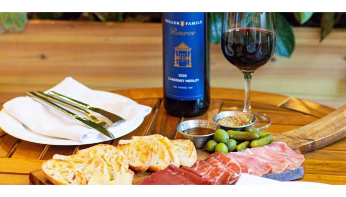 Charcuterie board with wine, bread, olives, and cured meats.