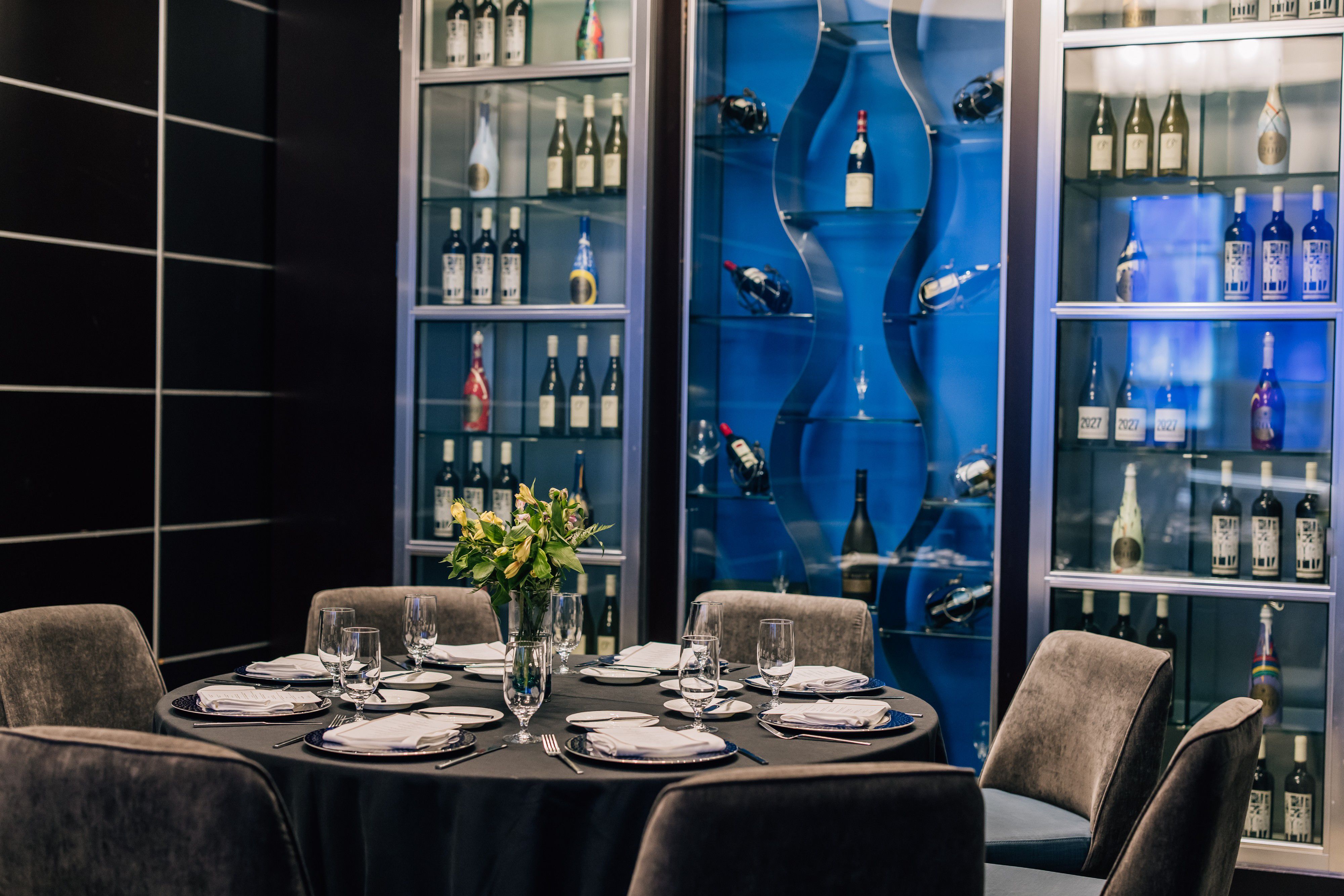 Private dining table surrounded by wine displays in an elegant tasting room